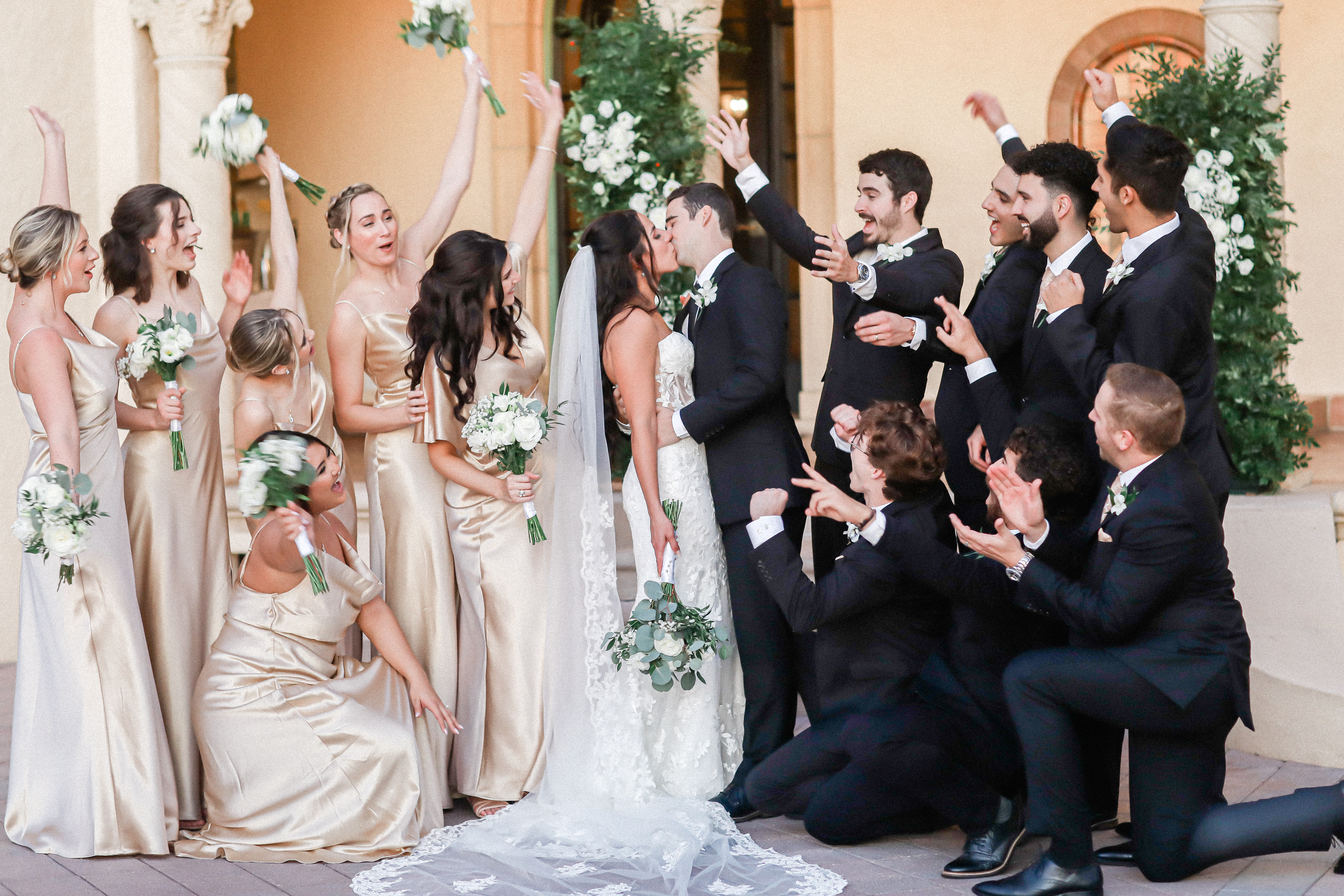 bridesmaids in cream dresses and groomsmen in black suits