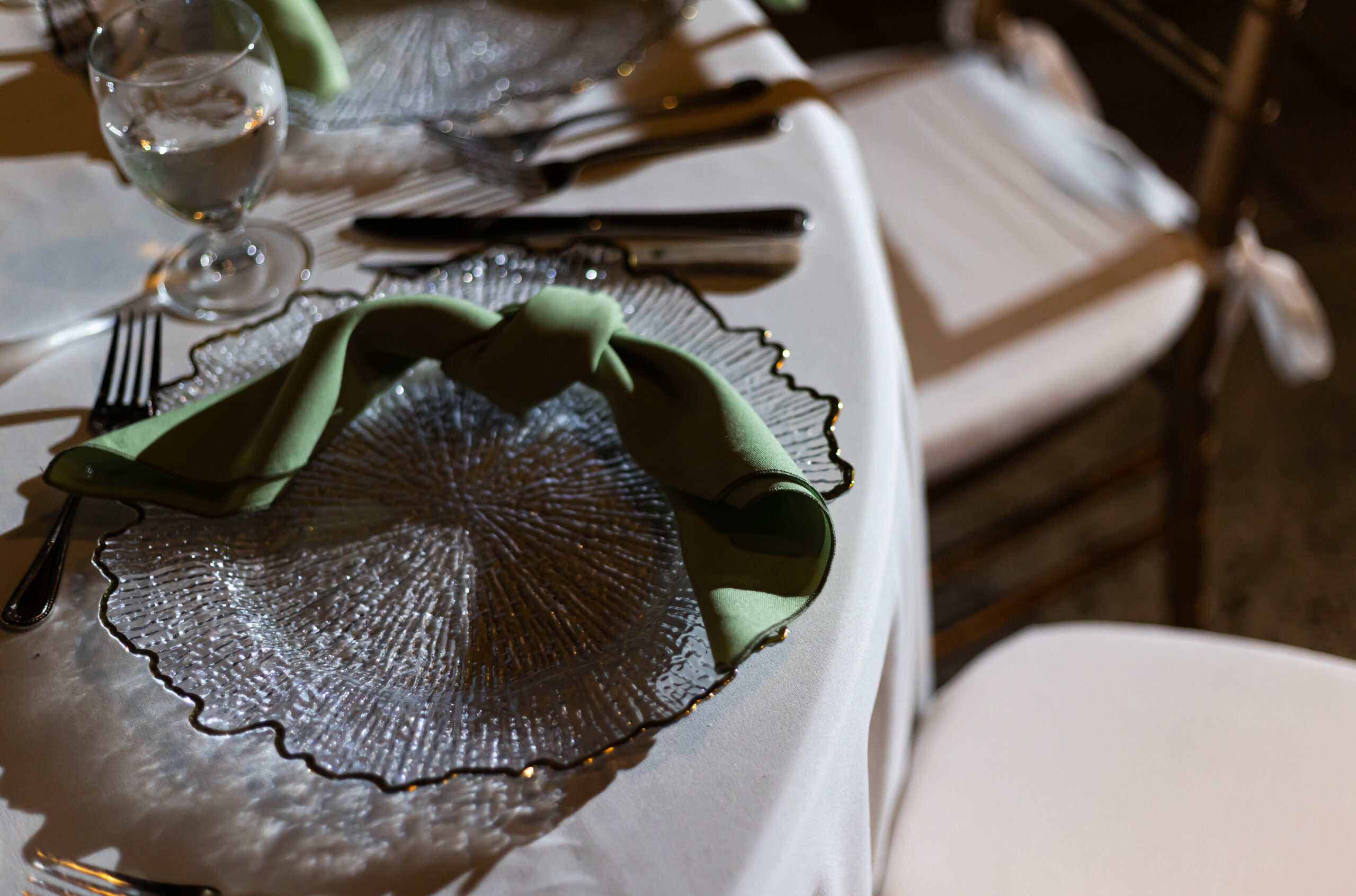 wedding tablescape with sage napkins and clear chargers