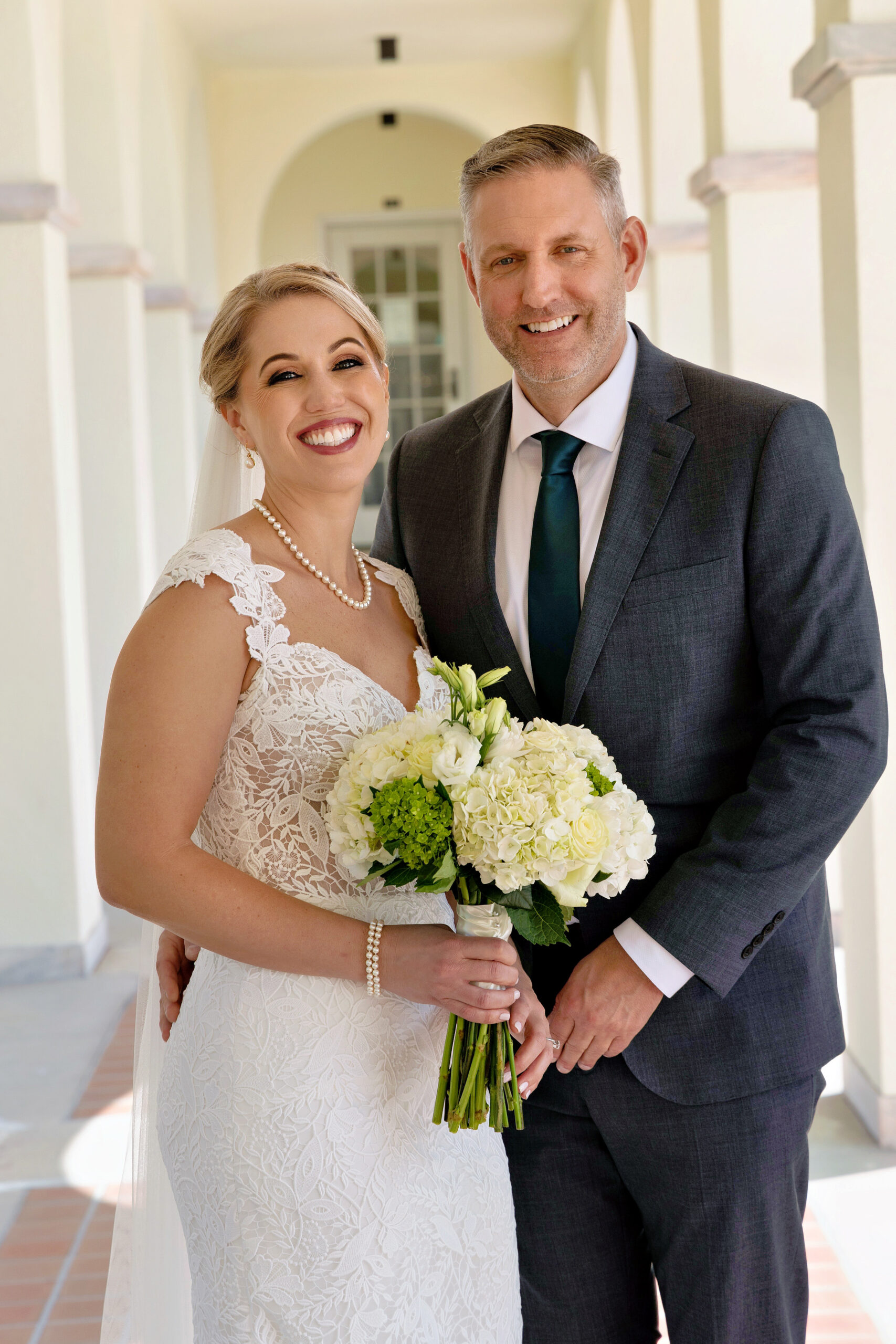 bride in classic lace gown and groom in dark gray suit