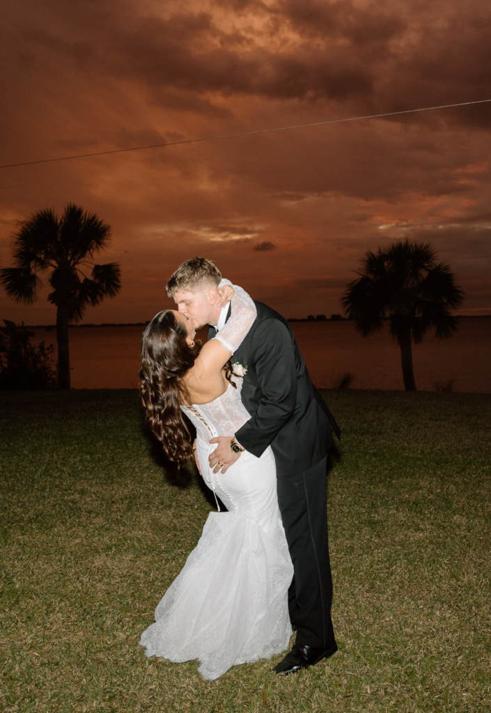 bride and groom by palm trees at Powel Crosley Estate