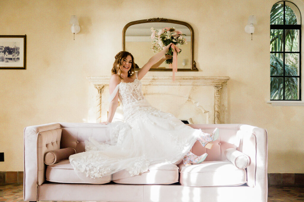 bride in elegant off shoulder lace wedding gown and pink shoes