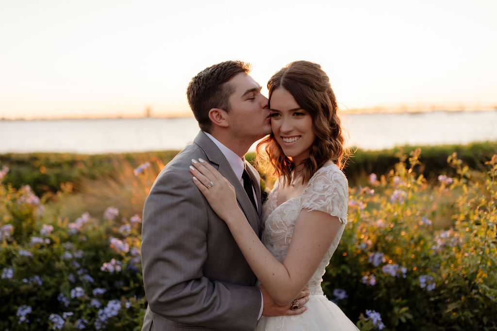 bride in lace and tulle gown and groom in gray suit