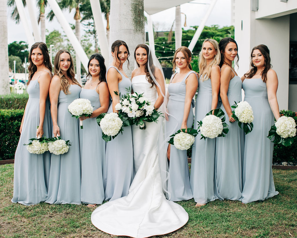 bridesmaids in teal dresses with white bouquets