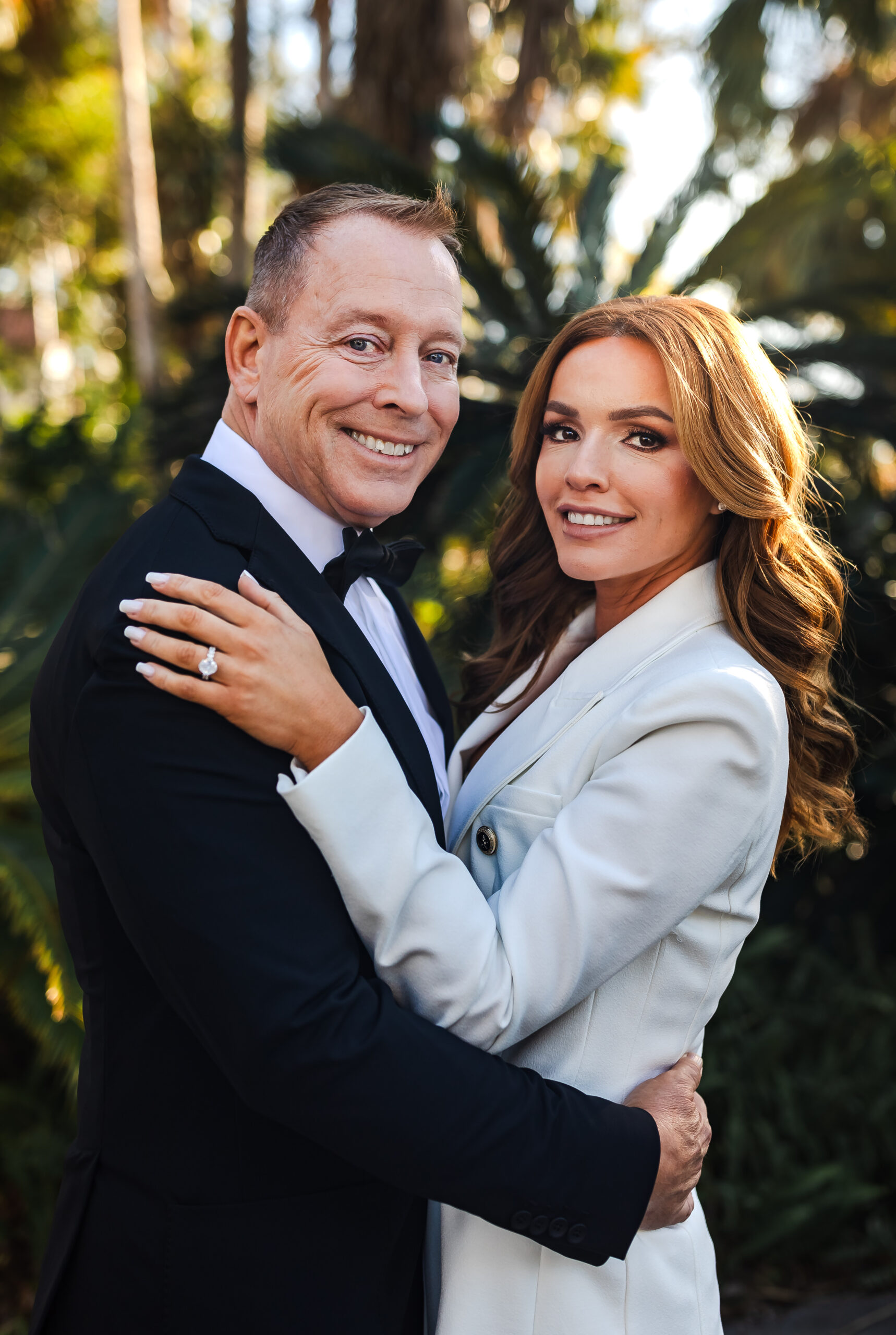 bride in white suit and groom in black tux