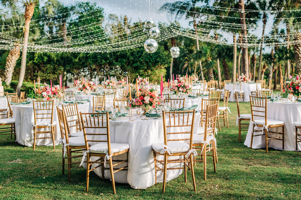 wedding reception with disco balls, stringed lights, and colorful centerpieces