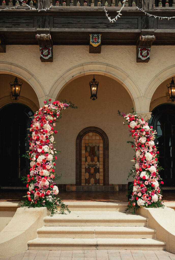 pink and red floral wedding ceremony arch