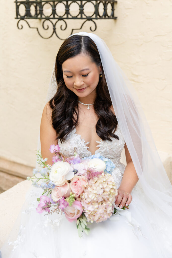 bride in tulle and lace wedding gown with pink and blue bridal bouquet