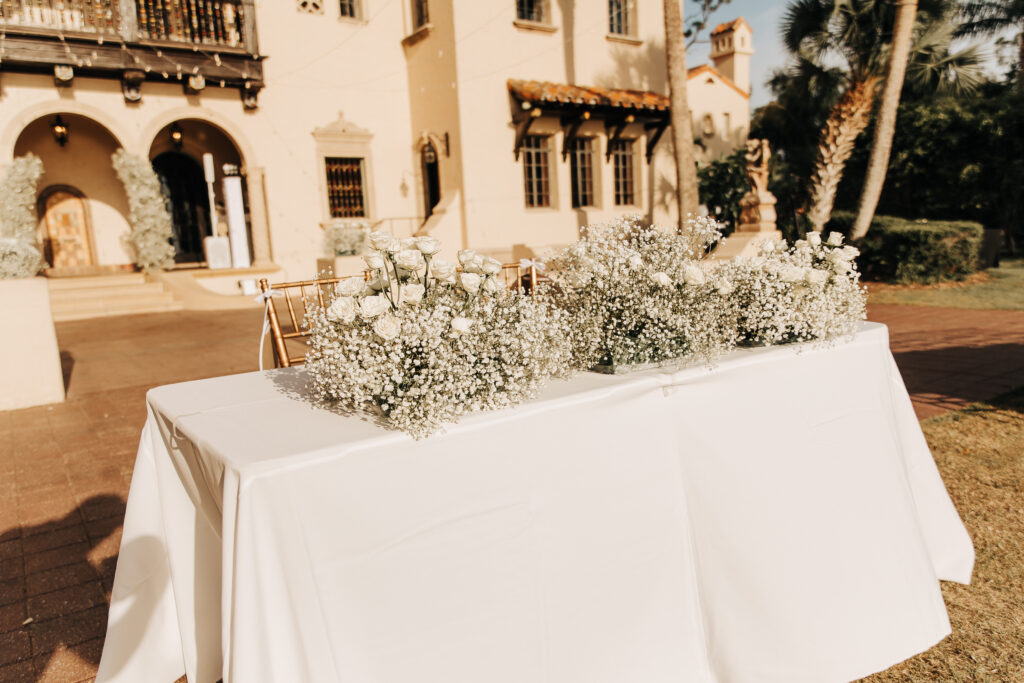 wedding sweetheart table decorated with white roses and baby's breath