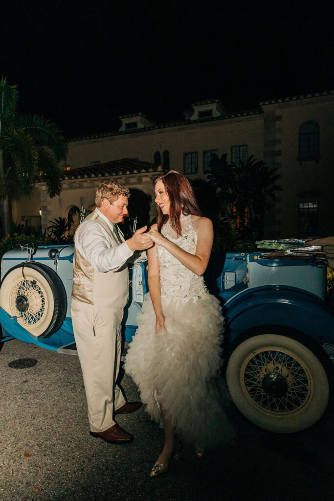 bride and groom with a classic car