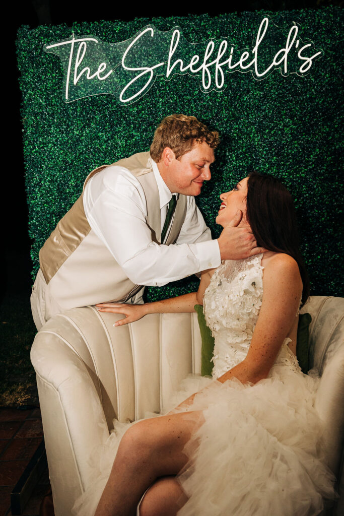 bride and groom portraits in front of greenery wall