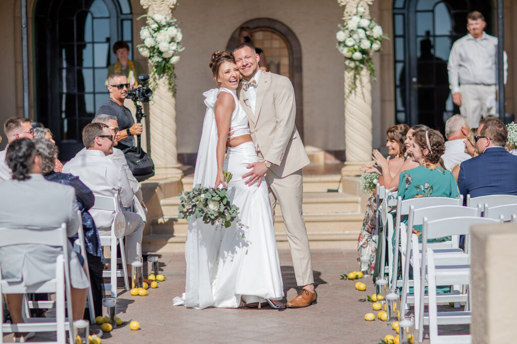 bride in two piece gown and groom in cream suit