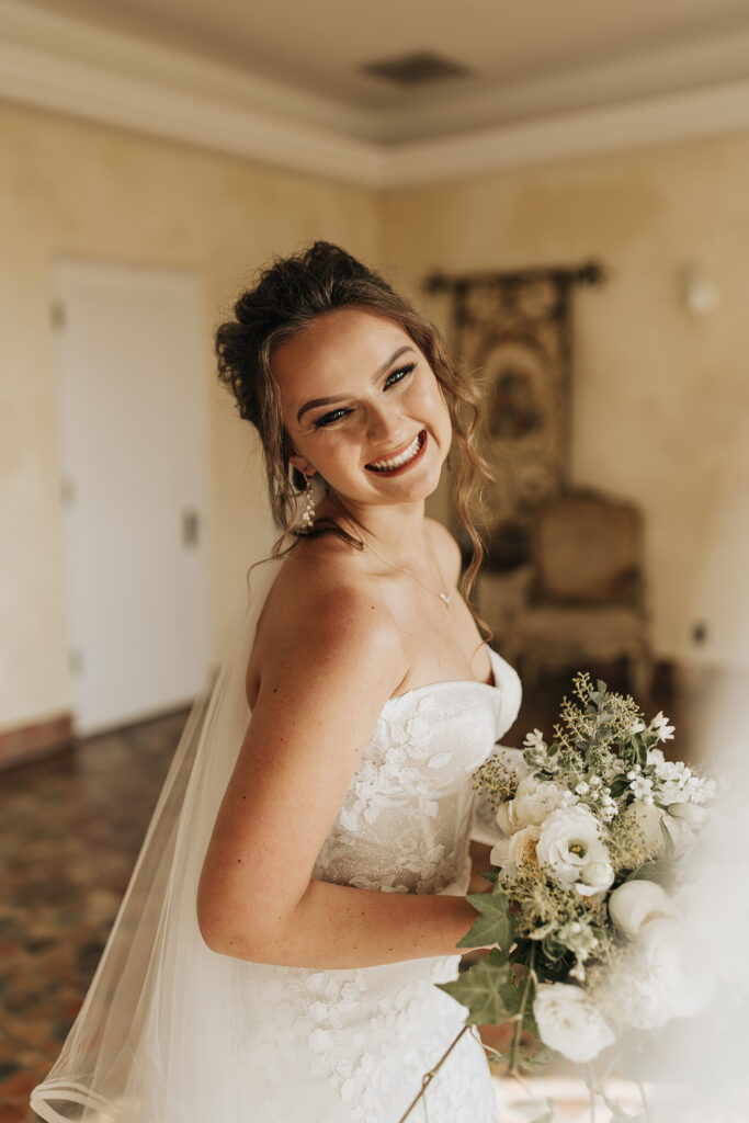 bride in lace floral gown with white and greenery bridal bouquet