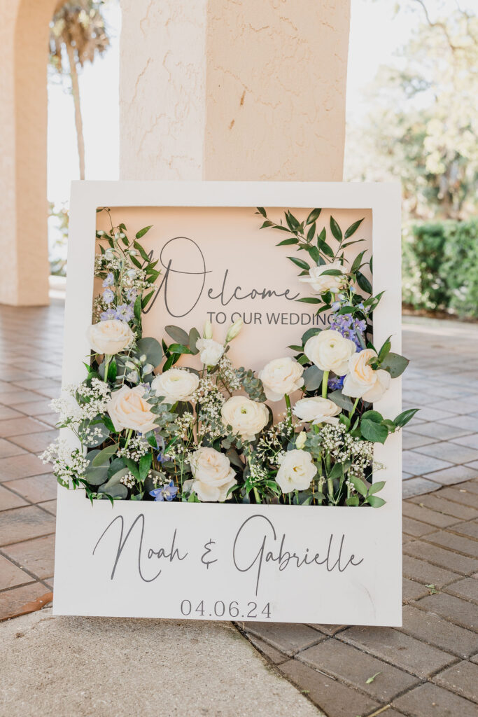 gorgeous wedding welcome sign with greenery and white roses