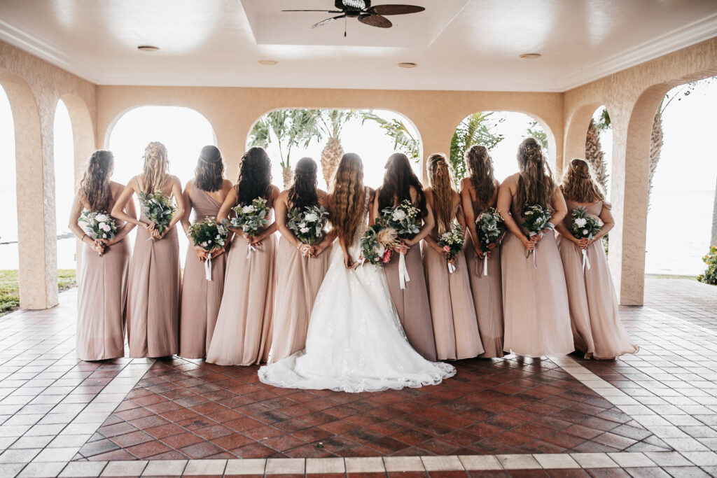 bridesmaids in tan dresses with green and white bouquets