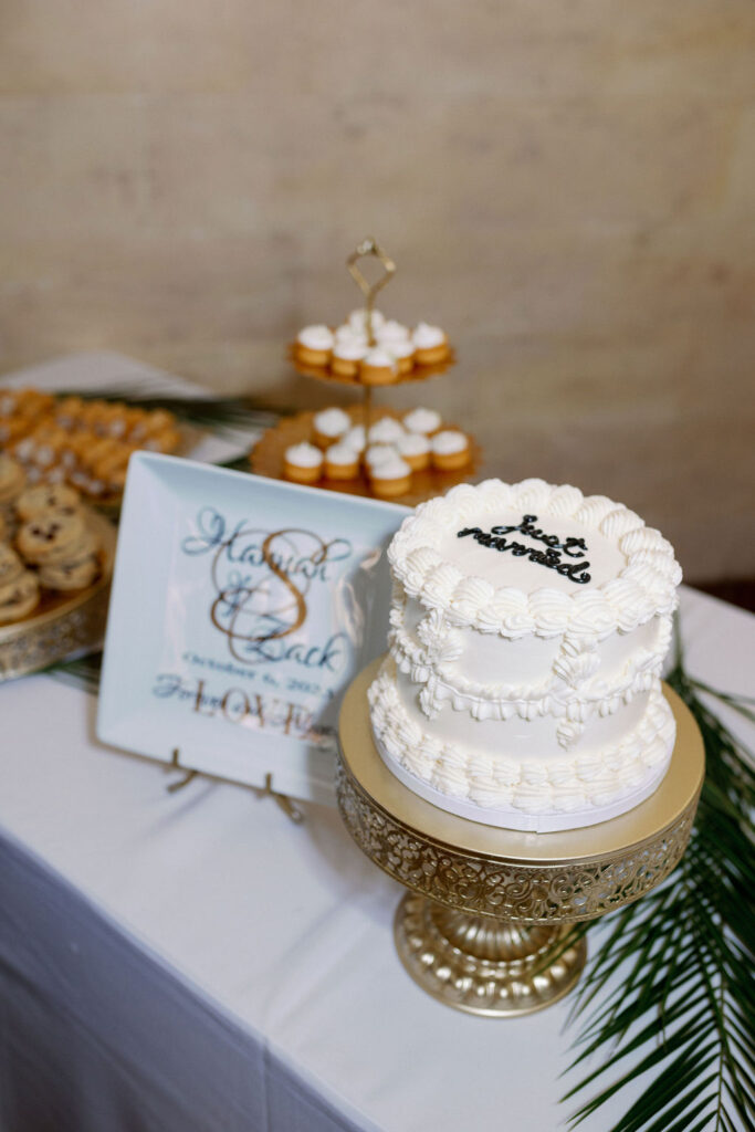 varied wedding dessert table with white cake, cookies, and cupcakes