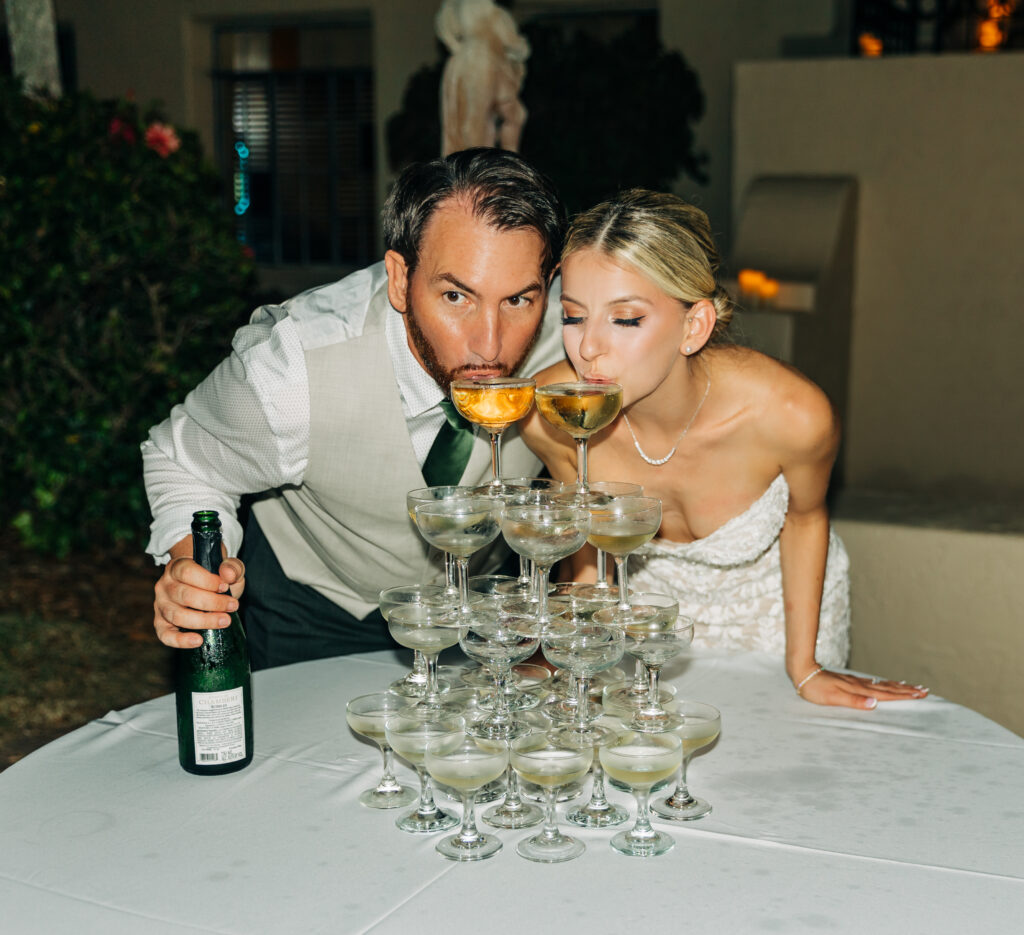 bride and groom drinking from champagne tower