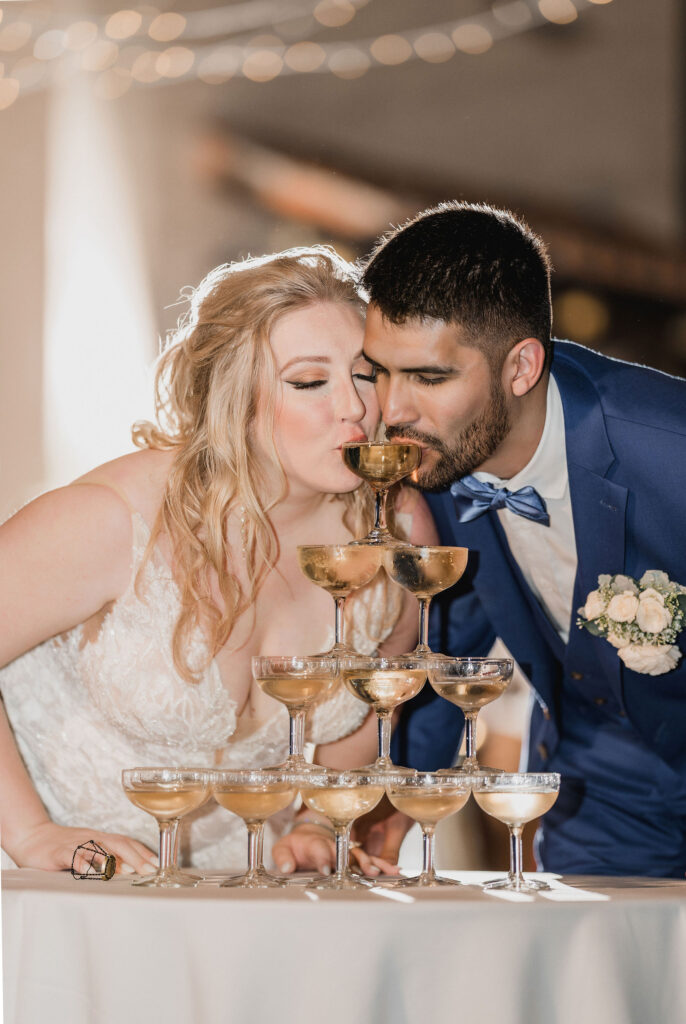 bride and groom drinking from champagne towner