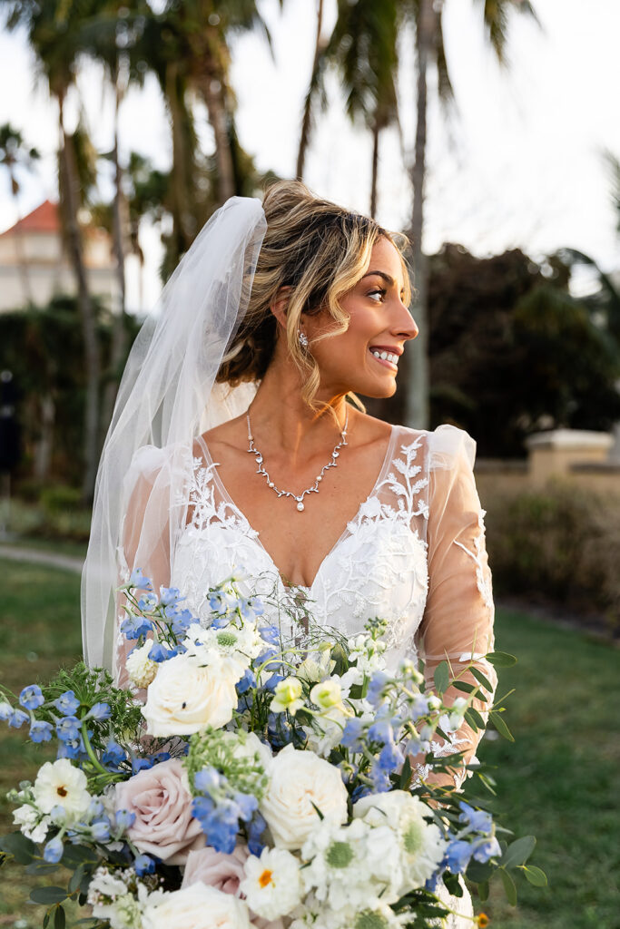 bride in lace gown with sleeves and with a colorful bridal bouquet