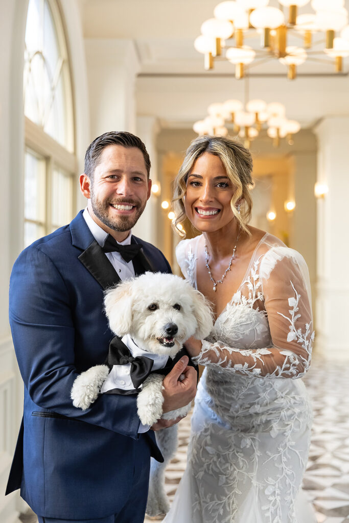 bride and groom with their dog in a tuxedo