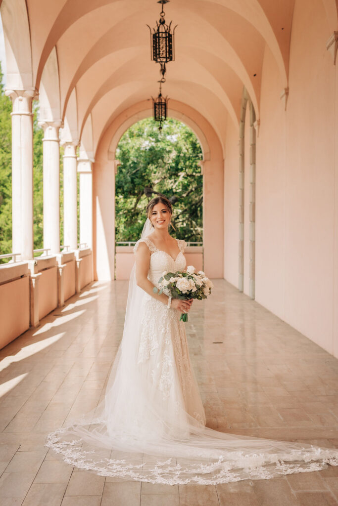 bride in lace gown with white floral bouquet