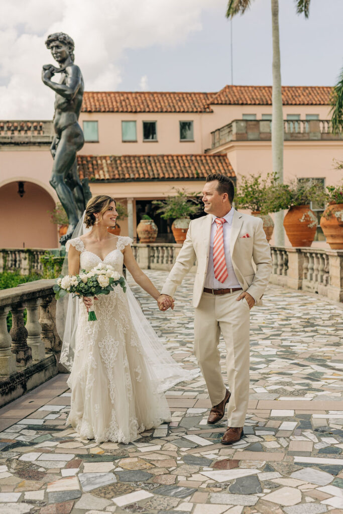 bride in tulle lace wedding gown and groom in tan suit with striped tie