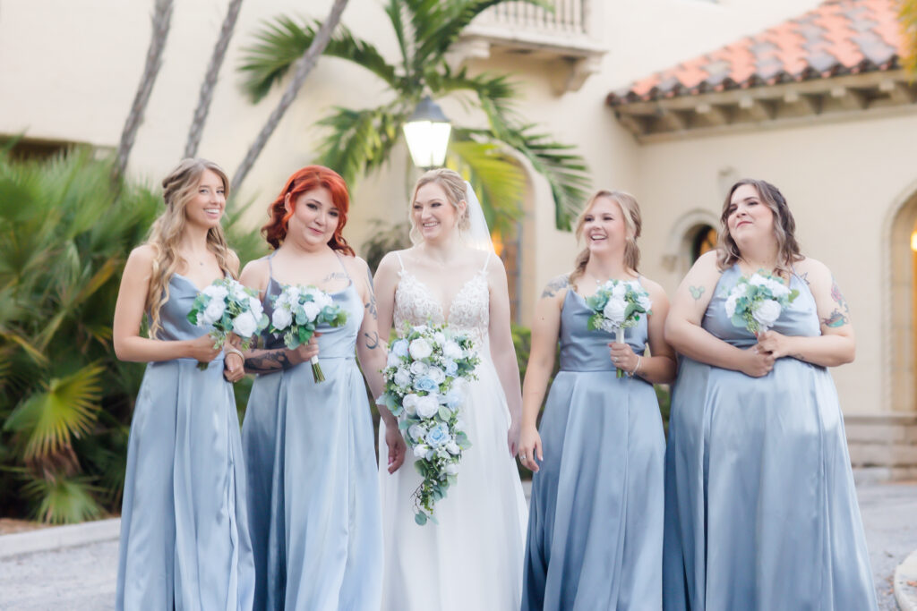 bridesmaids in blue gowns with blue and white bouquets