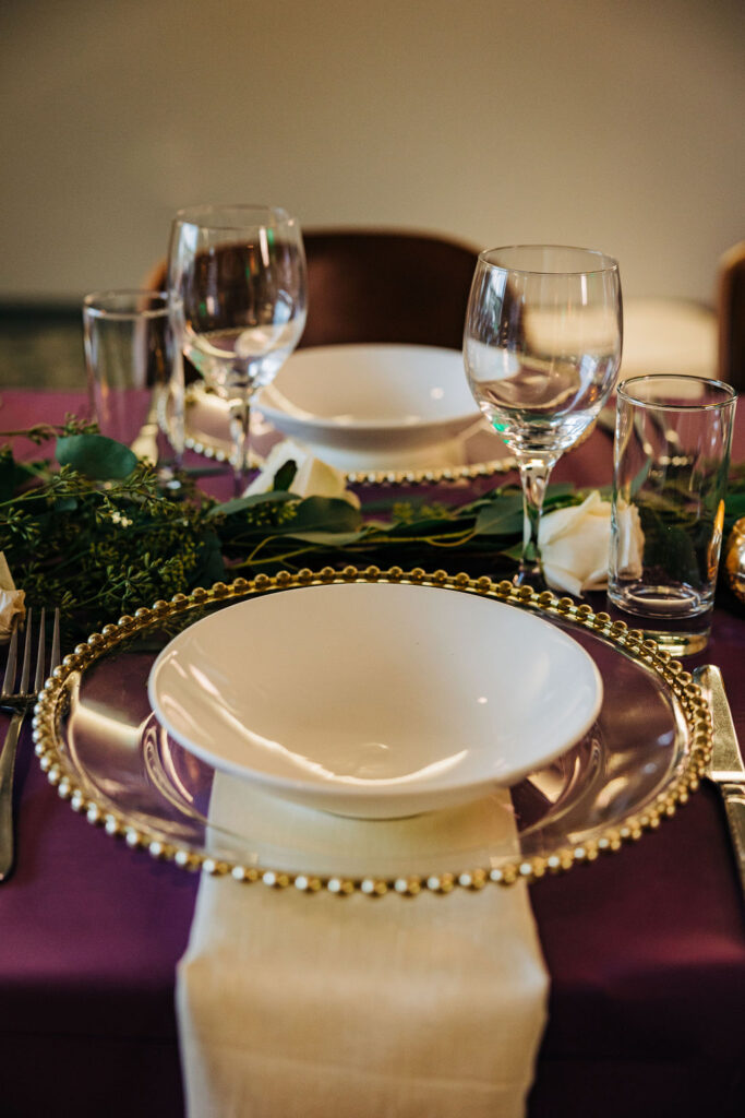 purple wedding tablescape with gold accented charger