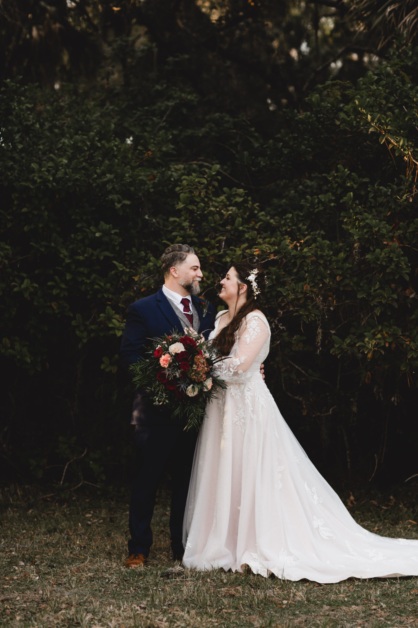 bride in elegant gown with lace accents and groom in navy suit