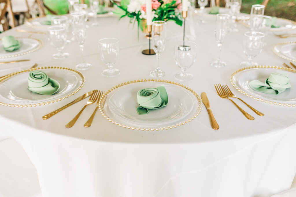 green and white wedding tablescape with rose-shaped napkins and pink accents