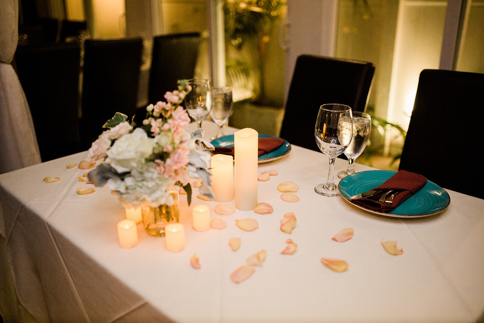 scattered petals, candles, and white and pink florals for wedding centerpiece