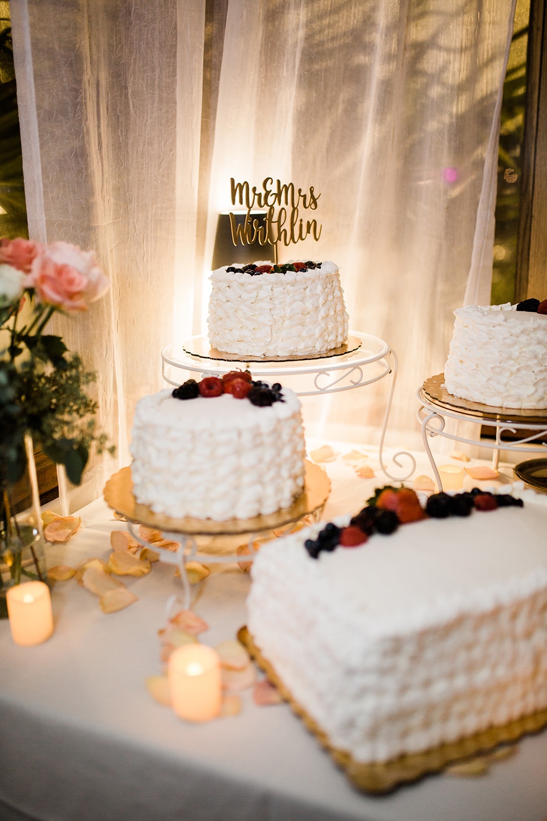 multiple white and fruit decorated wedding cakes