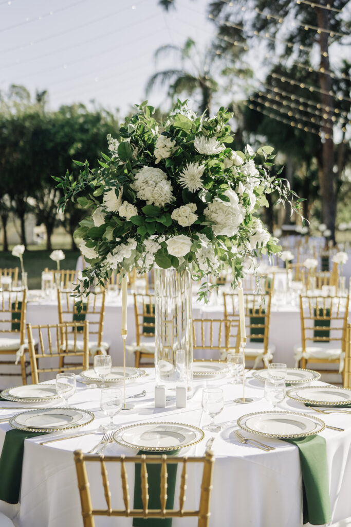 tall wedding centerpiece with white flowers and greenery, designed by Precious Moments Events