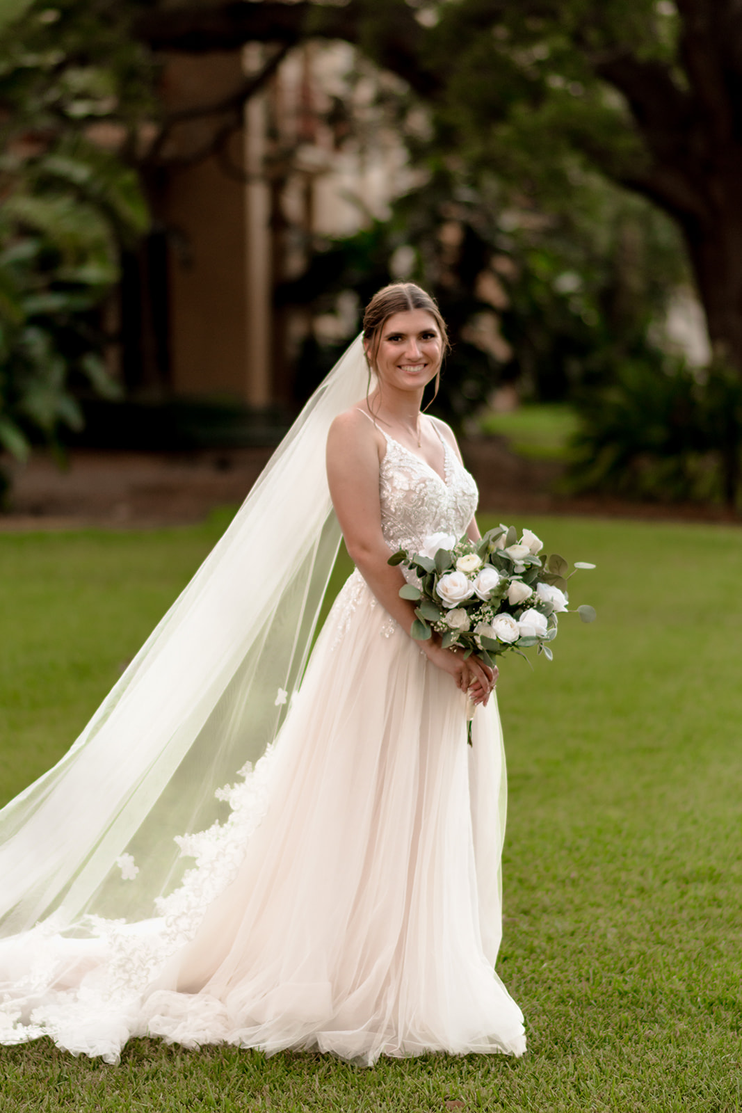 bride in embroidered tulle wedding gown with white bridal bouquet 