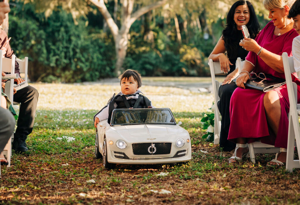 ring bearer going down aisle in toy car