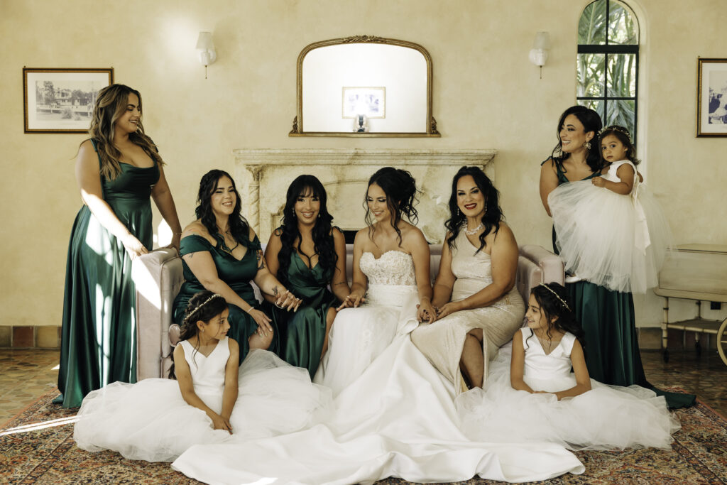 bridesmaids in emerald dresses and flower girls in white tulle dresses