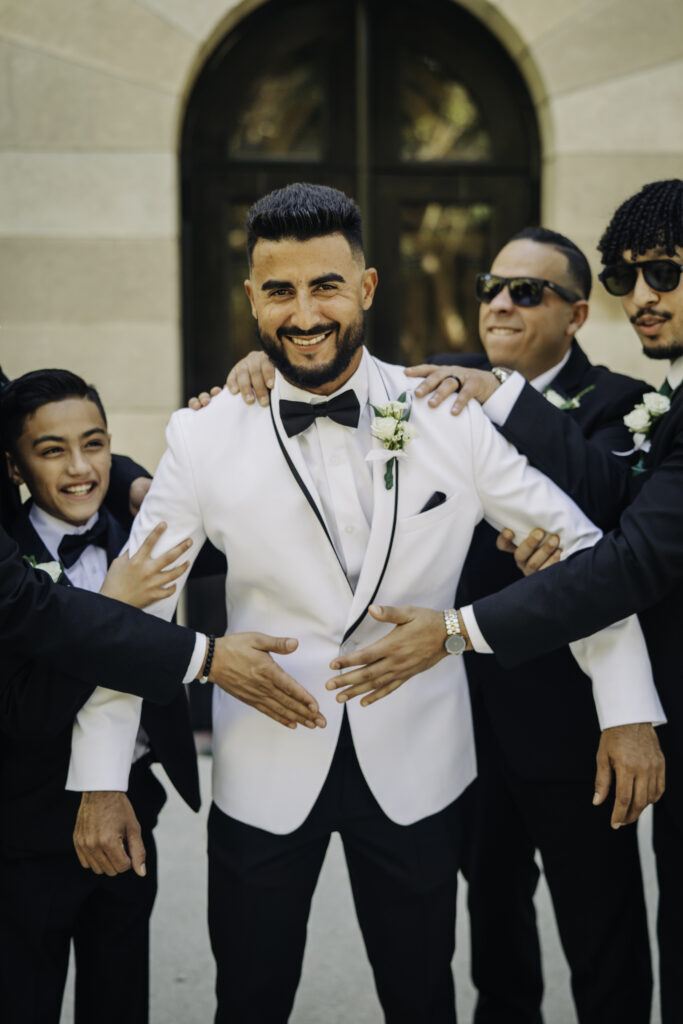 groom in classic white tux with black accents