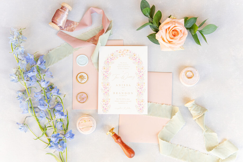 white and peach wedding invitation flatlay with florals