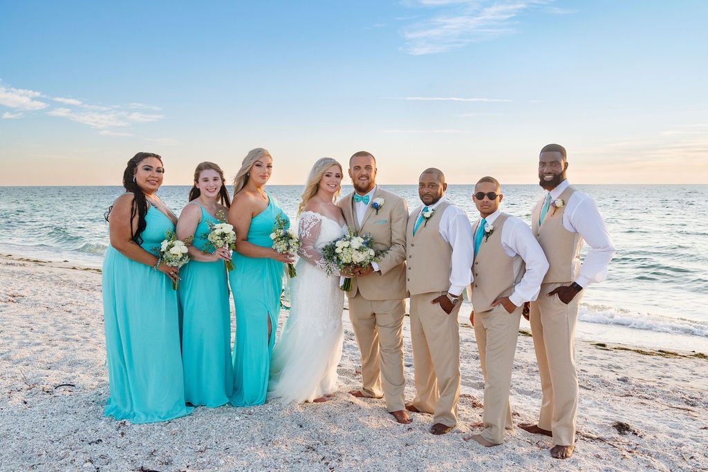 bridemaids in teal dresses and groomsmen in tan vests