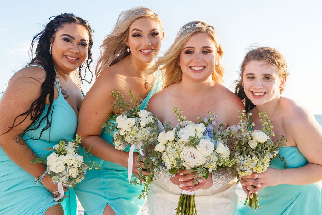 bridesmaids in teal dresses with white and green bouquets