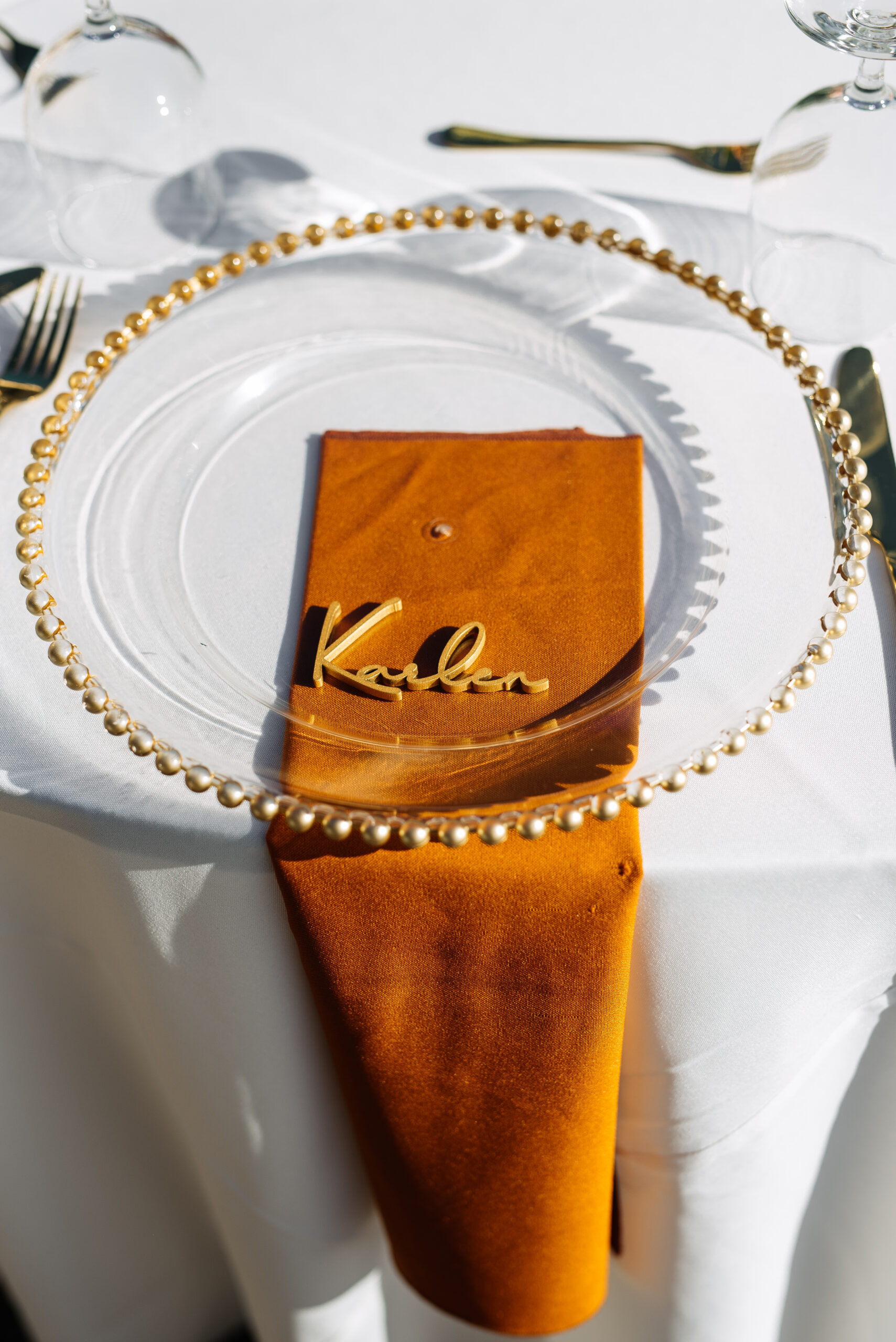 wedding reception table setting with gold and burnt orange details